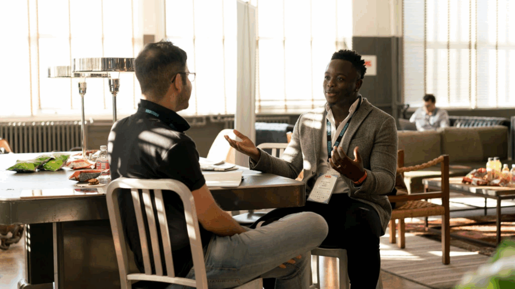 Two men engaged in a respectful discussion, demonstrating assertive communication in a professional setting.