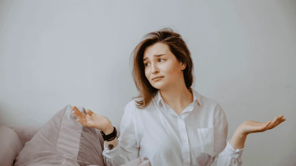 Woman in a white shirt shrugging with an uncertain expression, representing the need for brain-based strategies.