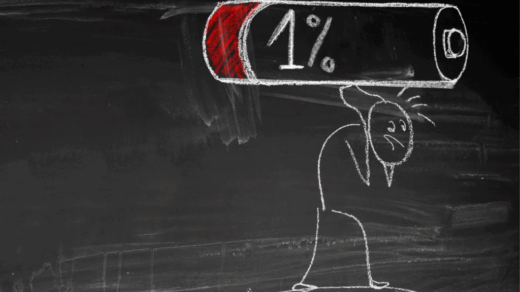 A stick figure holds a battery that is almost dead, symbolizing burnout.