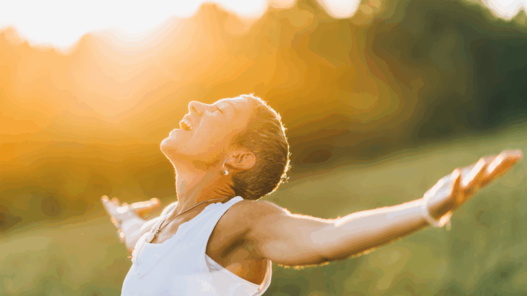 Woman with her arms spread wide against a glowing sun symbolizing how to make permanent life changes.