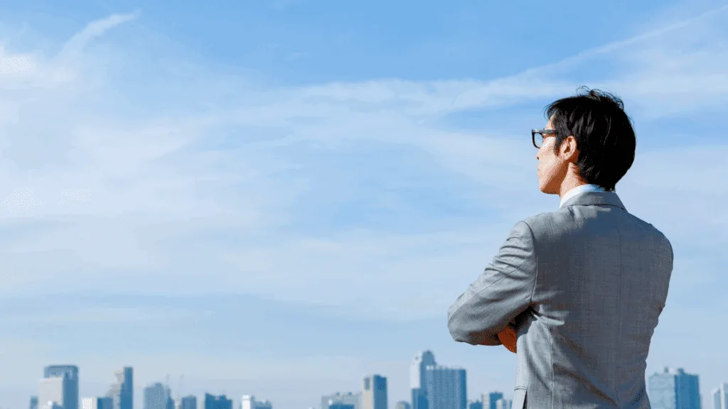 Business professional reflecting on the city skyline, symbolizing negative thoughts on career growth.