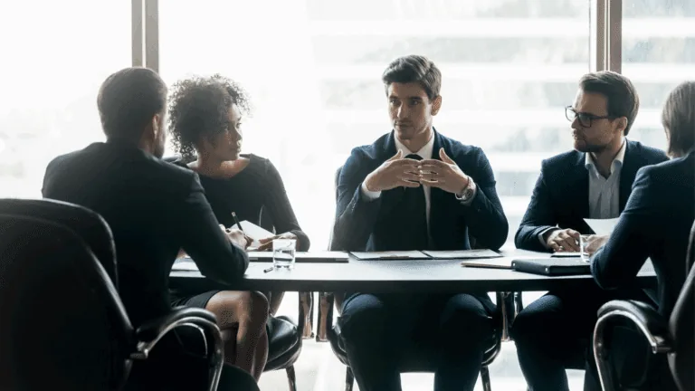 Leadership development shown by a group of executive professionals at a conference table who have learned neuroscience-based executive development