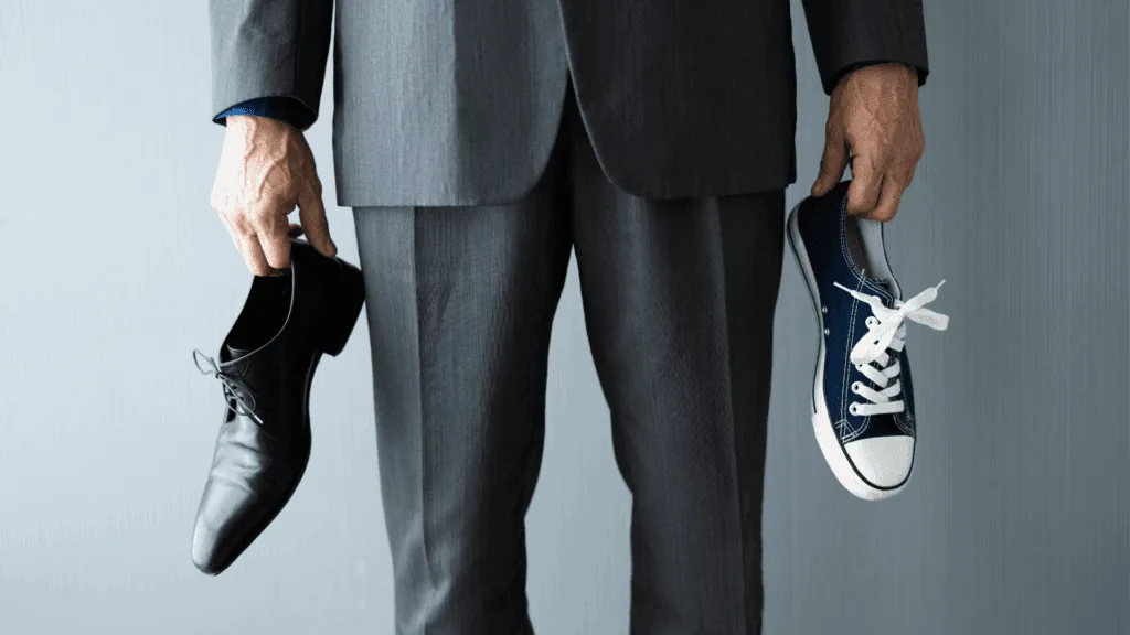 A man holding one work shoe and one sneaker depicting the concept of compartmentalization