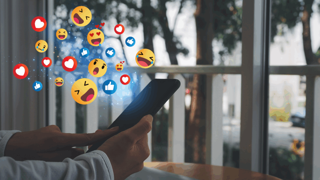 Emojis popping up from a phone describing the role social media has on the mental health among gen-z and millennials