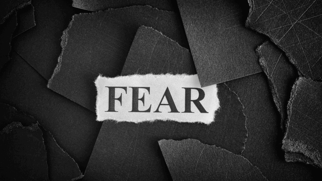 The word "fear" on torn black paper, symbolizing the fear of change.