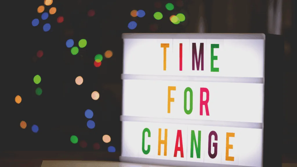 A lightbox with the phrase "Time for Change" illuminated against a festive, colorful background.