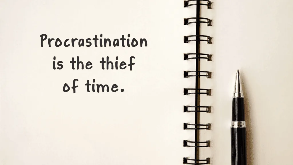 Open notebook with the phrase "Procrastination is the thief of time" written on a page.