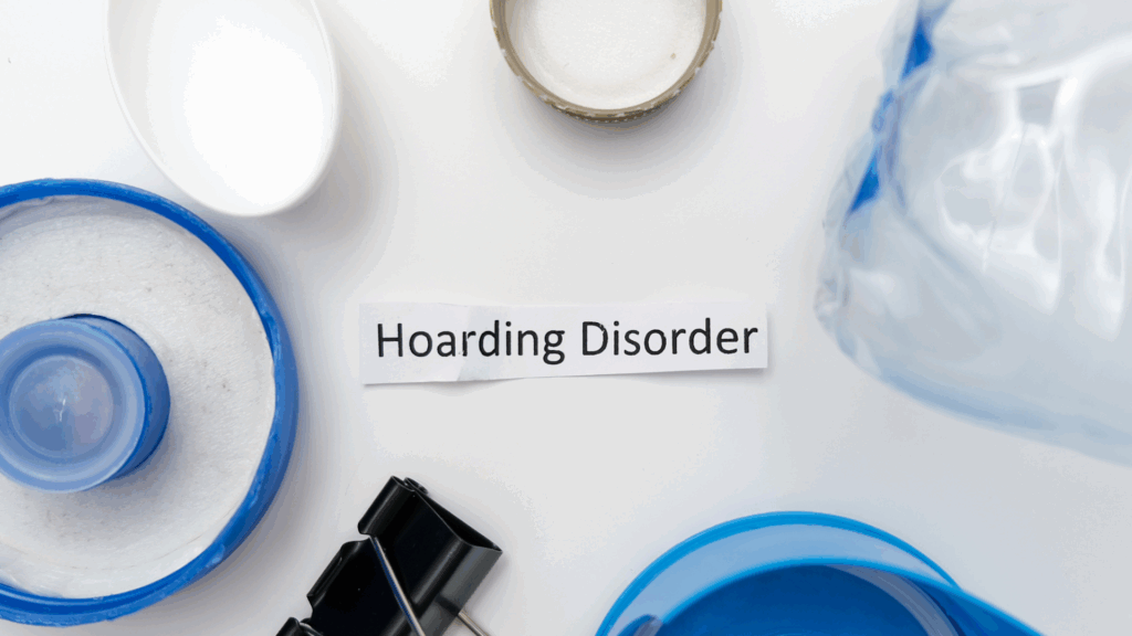 A sign reading Compulsive Hoarding surrounded by clutter, representing the impact of hoarding disorder.