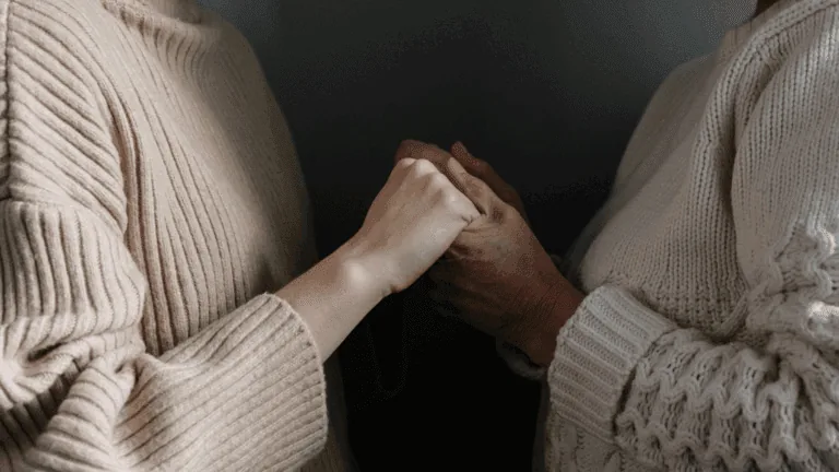 Two people holding hands for emotional support during reassurance-seeking