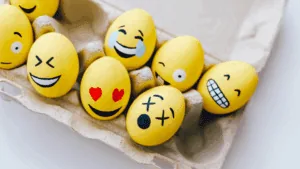 Eggs painted with expressive emoji faces, a playful way to explore and release emotions.