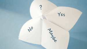 Paper fortune teller showing “Yes,” “No,” “Maybe,” and “?” options, symbolizing the dopamine paradox of uncertain rewards.