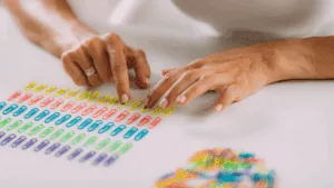 Hands arranging colorful paperclips in precise rows, illustrating repetitive compulsive behavior.