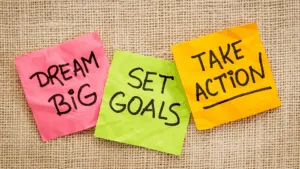 “Sticky notes with messages dream big, set goals, take action, symbolizing motivation in Dopamine-Aware Leadership.”