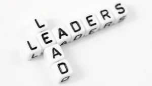 “White dice spelling the words lead and leaders, symbolizing guidance and growth through Neuroscience-Based Executive Coaching.”