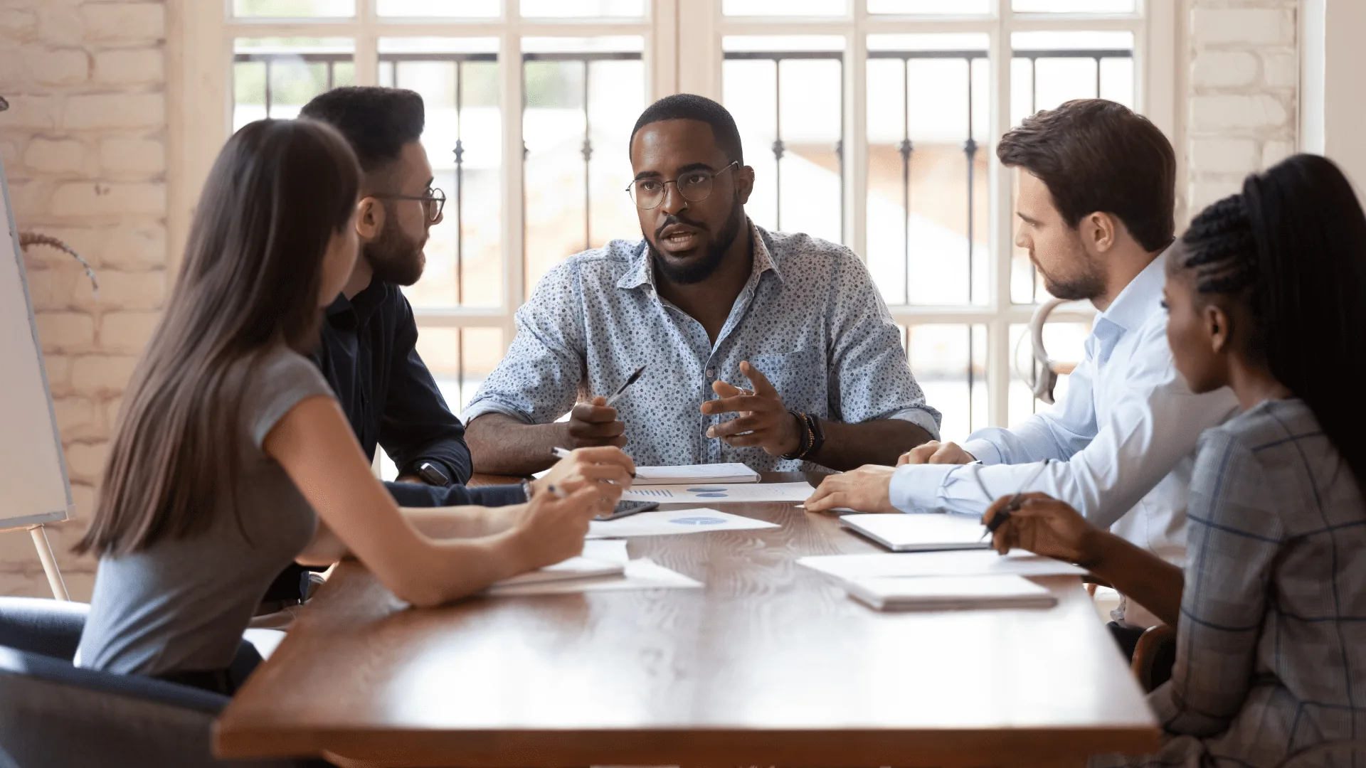 Business leader guiding a diverse team during a meeting