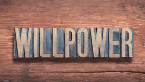 A wooden letterpress sign spelling the word willpower, symbolizing the importance of willpower and self-control.