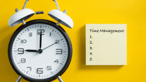 Clock beside a sticky note pad, symbolizing strategic planning to avoid time management mistakes.