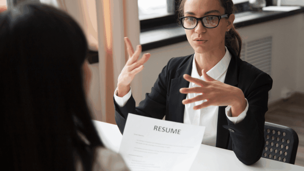 Professional woman conducting an interview, discussing a candidate’s resume during a job interview.