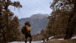 Hiker standing on a snowy trail overlooking mountain peaks, representing how nature helps calm the activity of your amygdala.