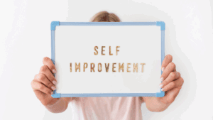 A woman holding up a whiteboard with the words "Self Improvement" in gold letters and a blue border. The image represents the concept of self-improvement and personal growth through brain-based life and performance coaching with Dr. Sydney Ceruto.