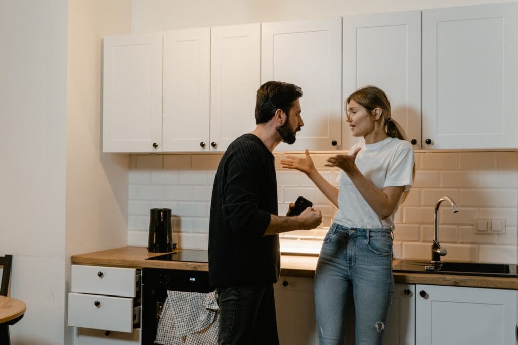 Man and woman arguing in kitchen during marriage conflict