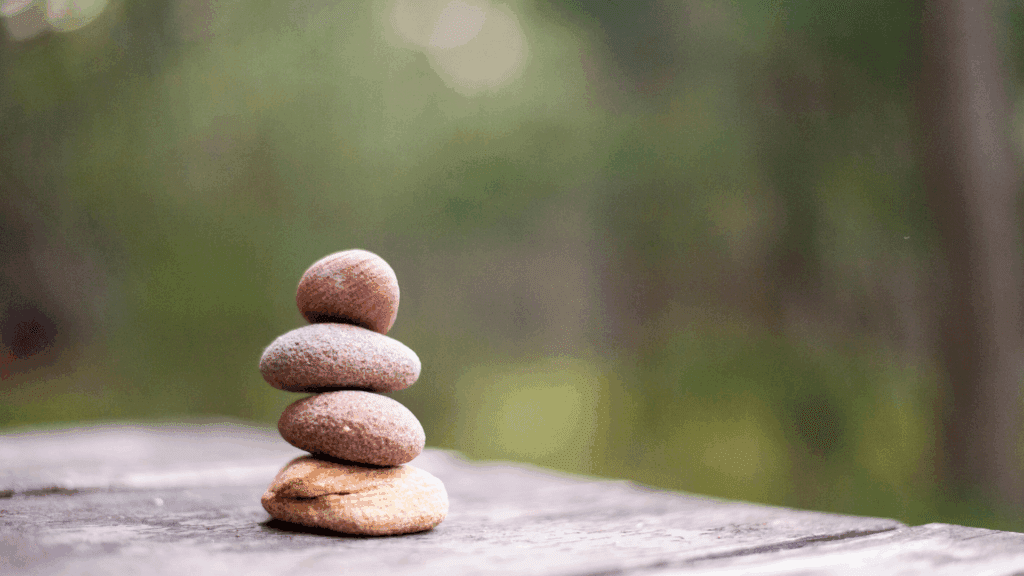 Stack of balanced stones on a wooden surface, symbolizing harmony and growth in neuroplasticity in brain development.