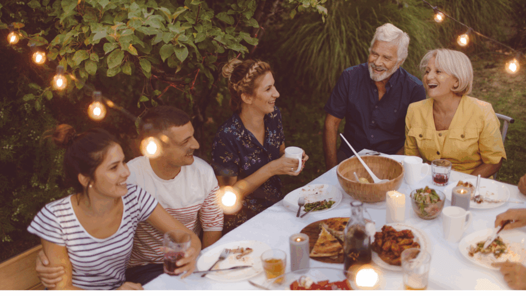 a group of people sitting at a table with food