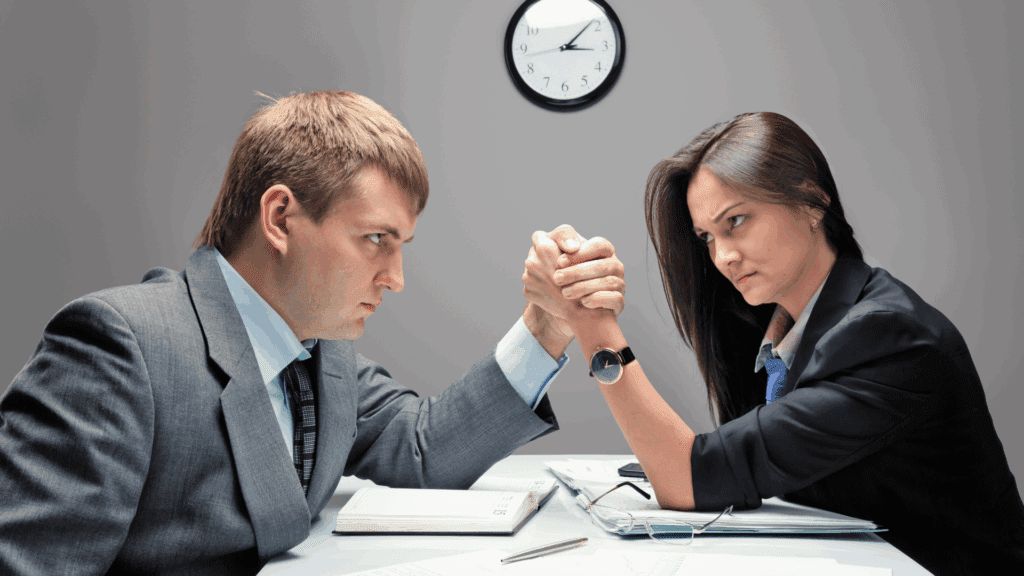 Two business professionals arm wrestling, illustrating competitiveness in Type 
