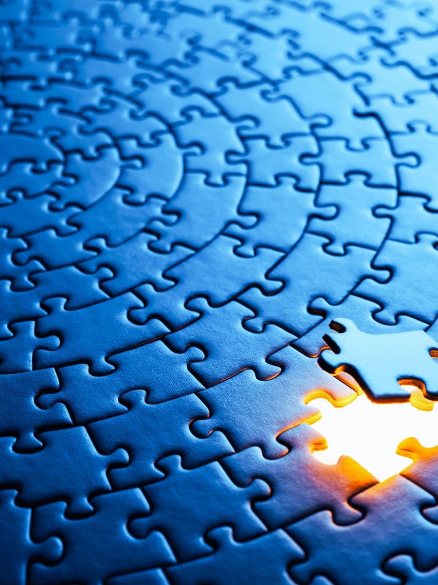 Process: glowing puzzle piece fitting into a blue puzzle, symbolizing MindLAB Neuroscience’s science-based Process for breakthrough transformation