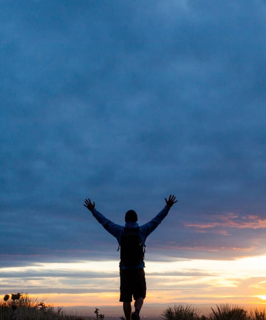 FAQ: silhouette with raised arms at sunrise, symbolizing empowerment through answers and science-based understanding at MindLAB Neuroscience