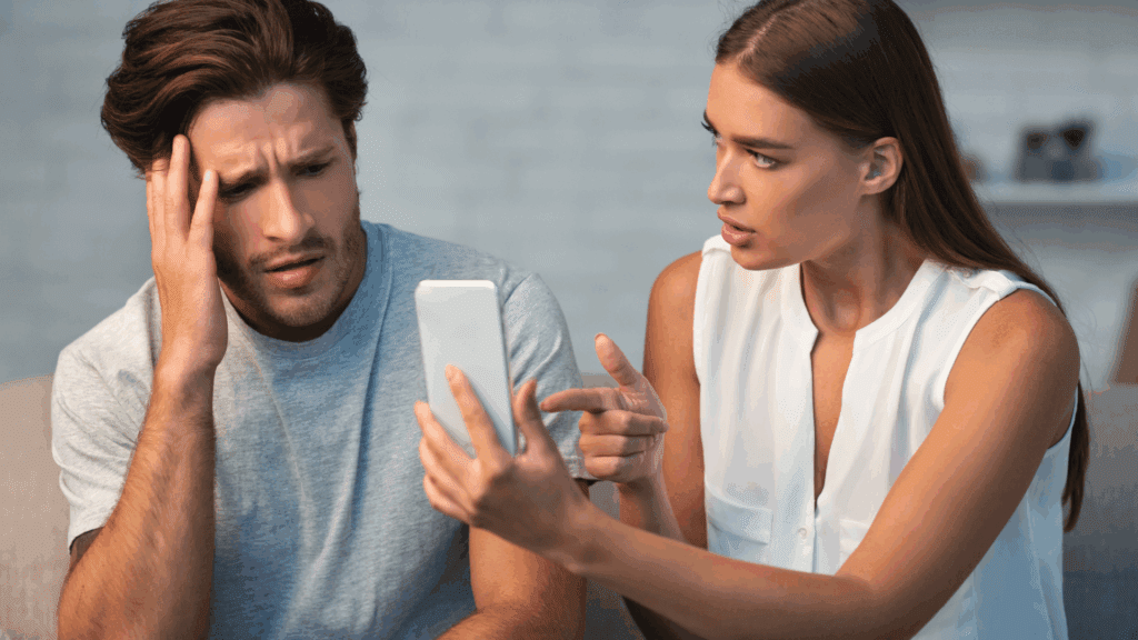 Person showing phone evidence while another reacts with distress, depicting moment of discovery