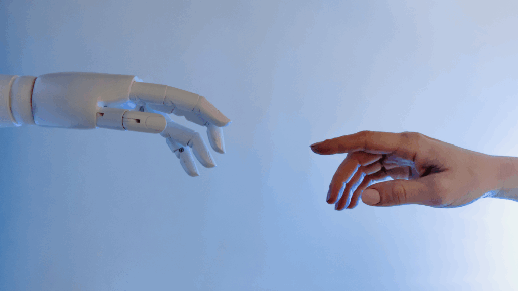 A robotic hand reaching out to touch a human hand, symbolizing the collaboration between AI and human intelligence in cognitive evolution.
