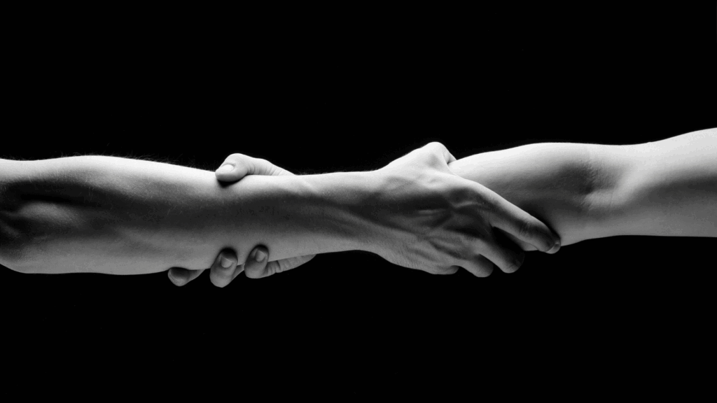 Two hands clasped tightly in black and white, symbolizing rebuilding trust and emotional connection.