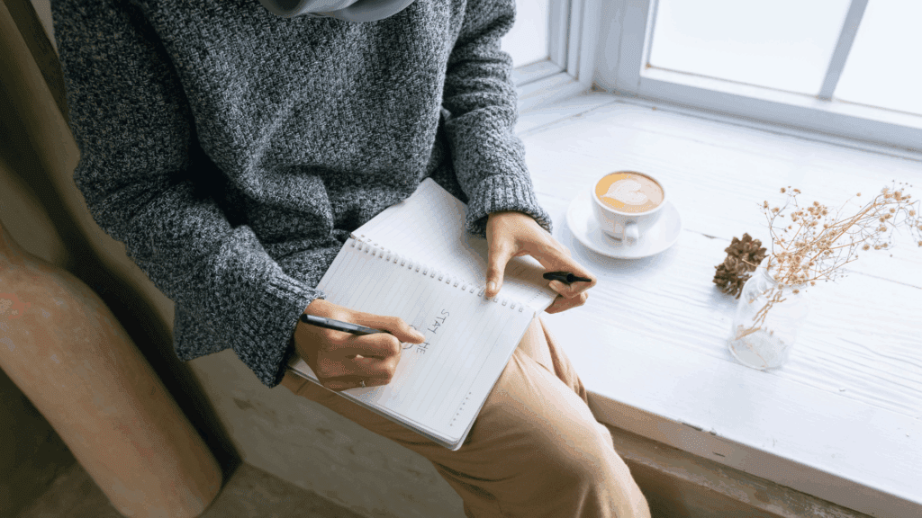 Person journaling to enhance self-awareness, a key step in building a success-focused mindset.