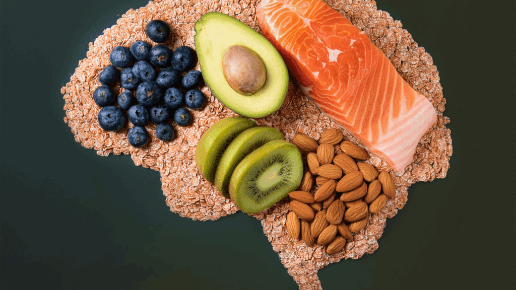 A variety of dopamine boosting foods including salmon, avocado, blueberries, kiwi, almonds, and oats arranged in the shape of a brain.