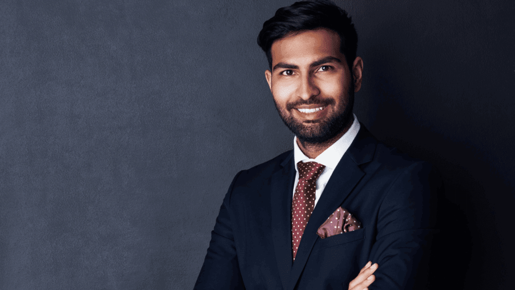 Confident businessman in a dark suit with a red polka dot tie, representing executive presence and professionalism.





