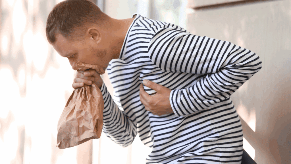 A person using a paper bag to manage symptoms, illustrating a physical response in the neuroscience of anxiety.