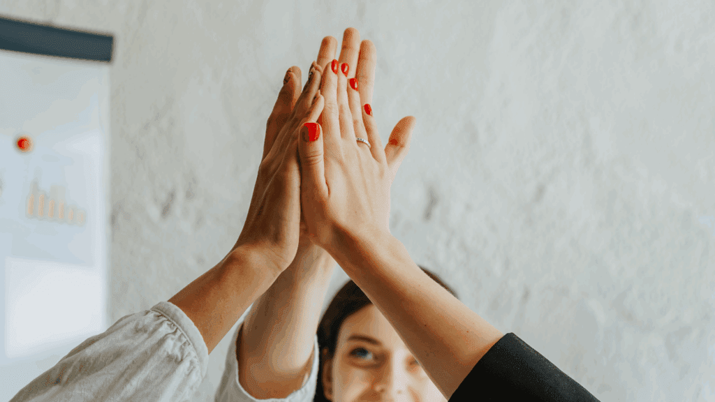 Group high five celebrating teamwork and the neuroscience of taking the high road