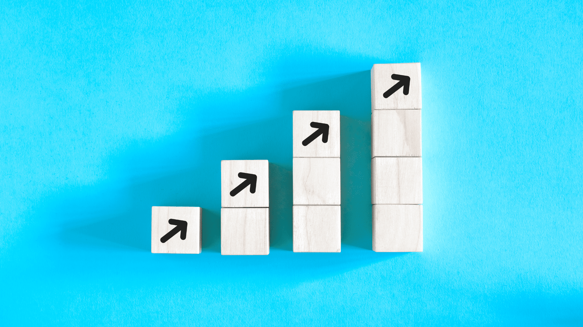 Wooden blocks stacked in ascending order with arrows pointing upward, symbolizing progress guided by a growth mindset coach.