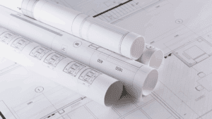 Architectural blueprints rolled on a table, symbolizing the structured design of the neuroscience of emotional awareness.