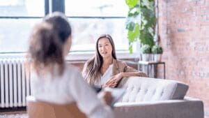 Woman speaking with a therapist in a bright office, illustrating neuroscience-based anxiety relief through counseling.