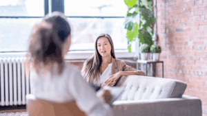 Woman speaking with a therapist in a bright office, illustrating neuroscience-based anxiety relief through counseling.