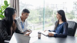 “Business professionals smiling during an interview, symbolizing leadership development through Neuroscience-Based Executive Coaching.”