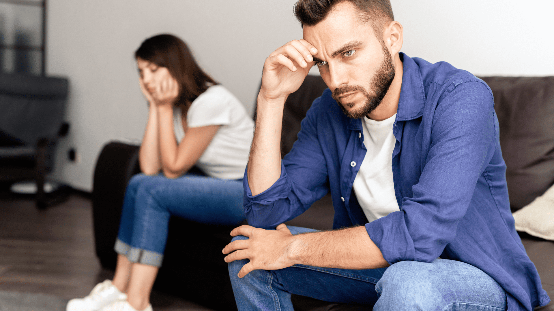 Man and woman sitting apart after an argument, illustrating emotional distance and why men struggle with intimacy.