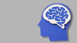 Blue paper cutout of a human head with a brain illustration, symbolizing the psychology behind why we want what we can't have.