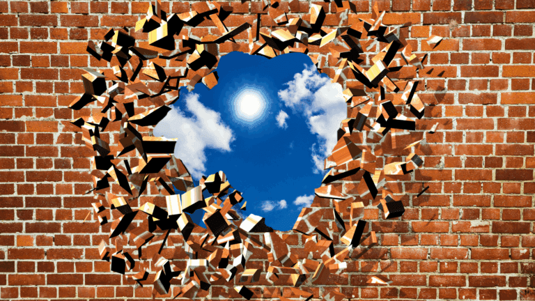 Brick wall breaking through showing breakthrough and freedom from anxiety for high performers.