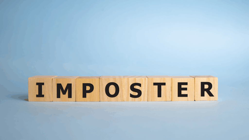  Wooden blocks spelling imposter, representing the core theme of imposter syndrome leadership coaching.


