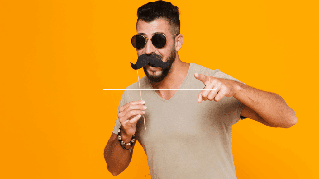 Young man in sunglasses with a fake mustache, illustrating imposter syndrome in leadership coaching.