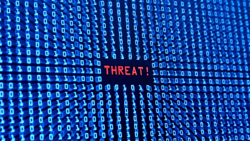 Red threat alert in binary code representing how amygdala detects threats in life coaching vs neuroscience coaching stress management

