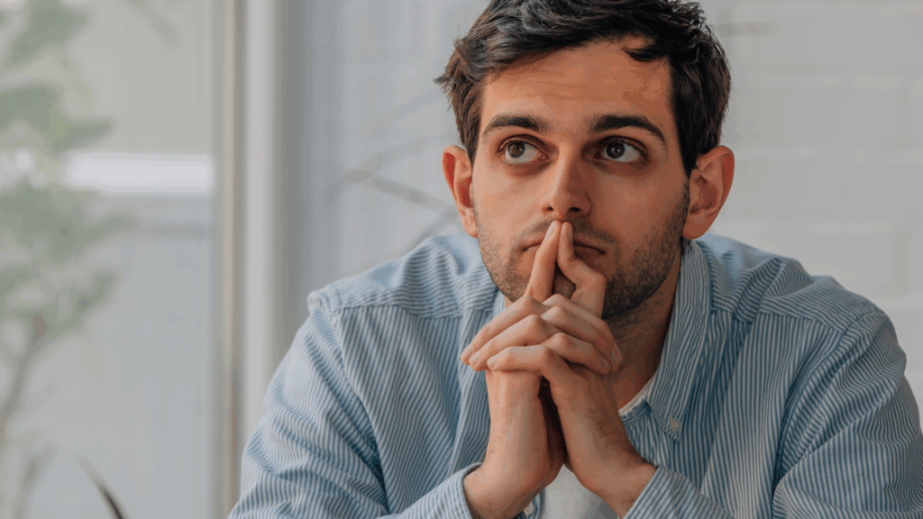 Thoughtful professional man considering his options in life coaching vs neuroscience coaching decision